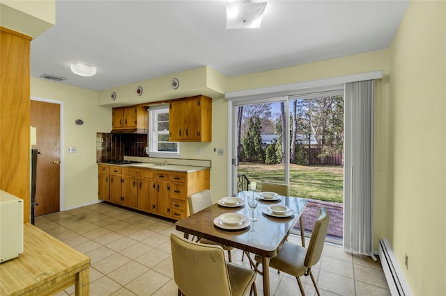 12 Harvard Dr, Hampton Bays, NY 11946 - dining space featuring a baseboard heating unit and light tile patterned floors