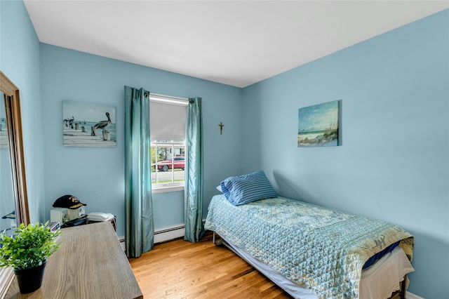 12 Harvard Dr, Hampton Bays, NY 11946 - bedroom with a baseboard heating unit and light wood-type flooring