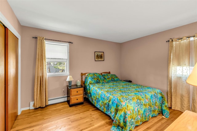 12 Harvard Dr, Hampton Bays, NY 11946 - bedroom with light wood-style floors, a closet, and a baseboard heating unit