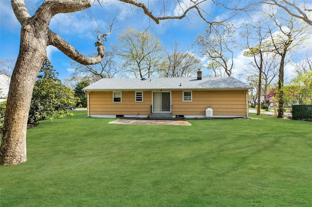 12 Harvard Dr, Hampton Bays, NY 11946 - rear view of house featuring a lawn, a chimney, entry steps, and roof with shingles
