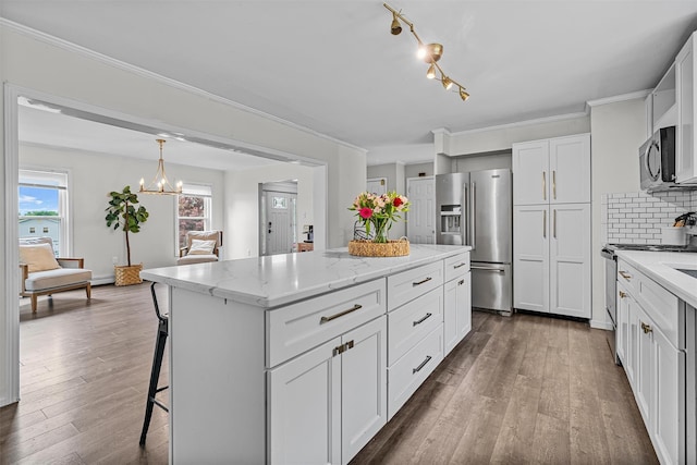 8 Red Oak Ct, Middletown, NY 10941 - kitchen with stainless steel appliances, a kitchen island, light stone counters, a breakfast bar area, and dark wood finished floors
