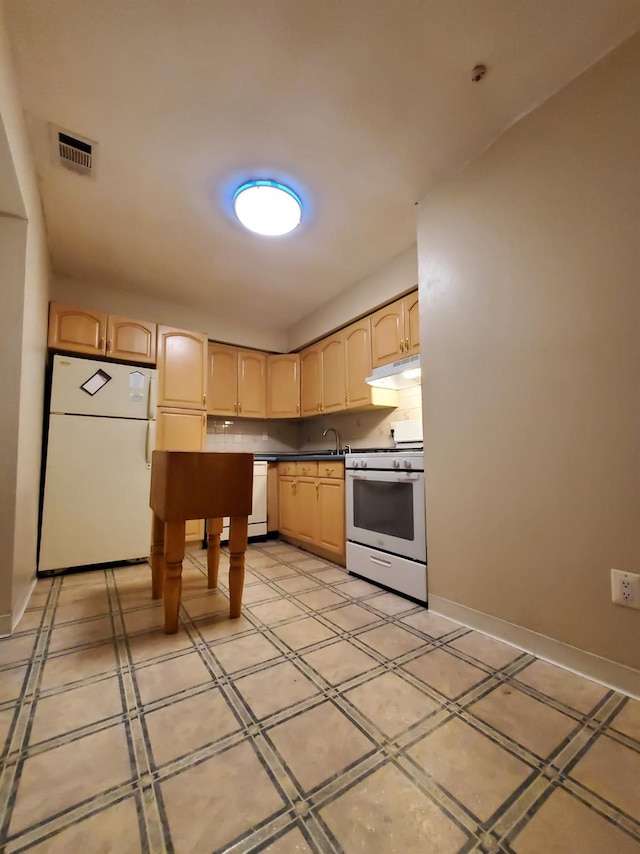 kitchen featuring white appliances, under cabinet range hood, light brown cabinets, a sink, and baseboards