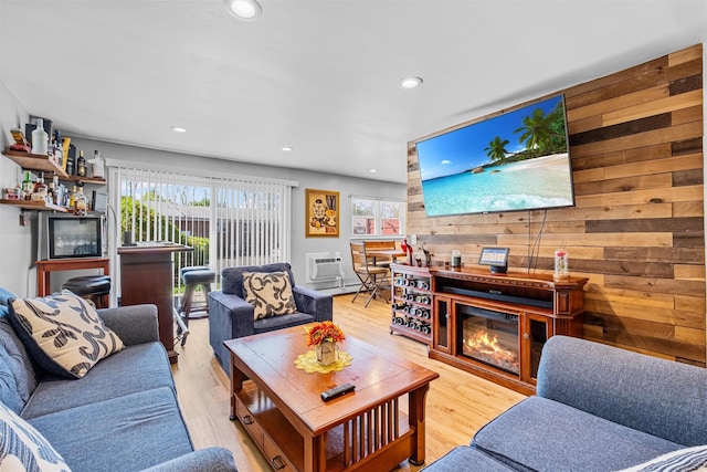 living area featuring wood walls, light wood finished floors, recessed lighting, and a wall mounted air conditioner