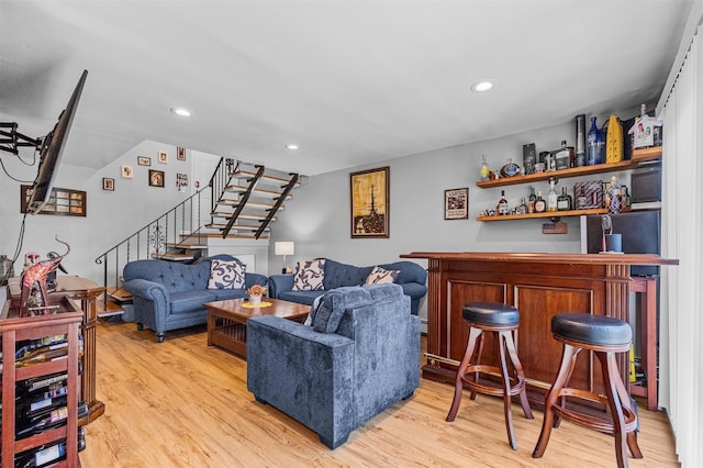 living area with stairway, a bar, light wood-type flooring, and recessed lighting