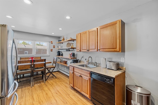 kitchen with black dishwasher, a sink, freestanding refrigerator, light wood finished floors, and recessed lighting