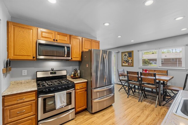 kitchen featuring appliances with stainless steel finishes, recessed lighting, light wood-style floors, and brown cabinets