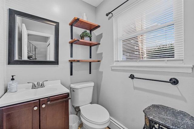 bathroom with toilet, healthy amount of natural light, vanity, and baseboards