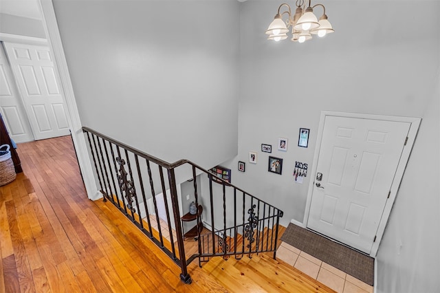 staircase with a chandelier and hardwood / wood-style floors