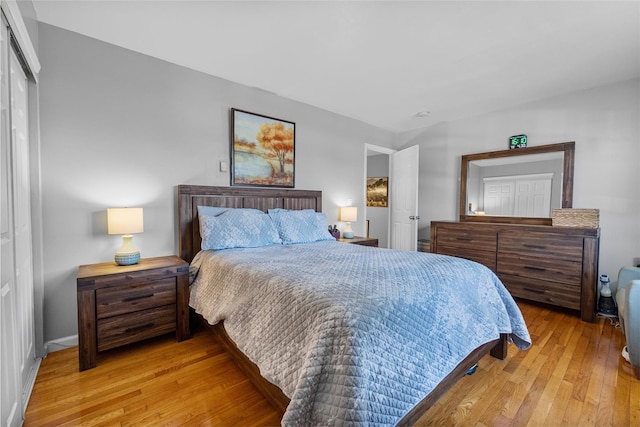 bedroom featuring wood-type flooring, a closet, and baseboards