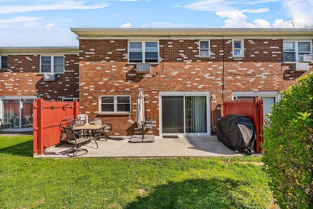 rear view of property featuring a patio and brick siding