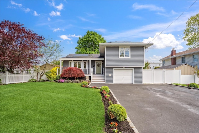 split level home featuring roof mounted solar panels, driveway, and an attached garage