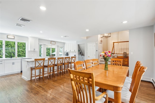 dining space featuring light wood-type flooring, recessed lighting, and a chandelier