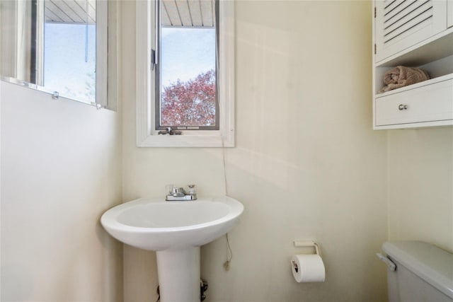 bathroom featuring healthy amount of natural light and toilet