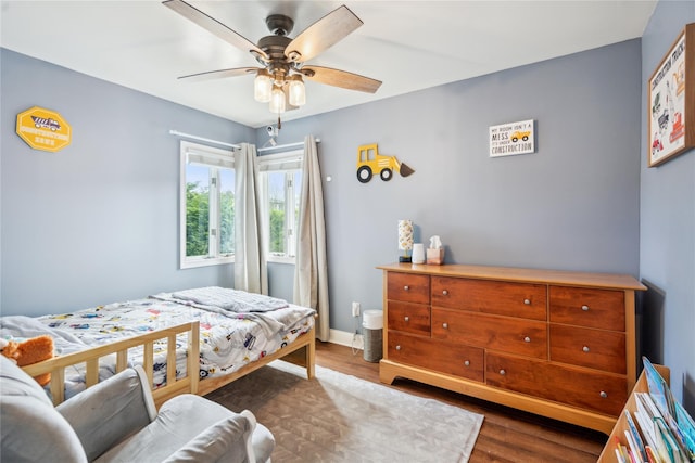 bedroom with wood finished floors, a ceiling fan, and baseboards