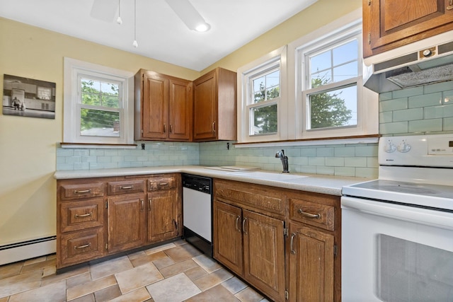 803 Oakwood Dr, Peekskill, NY 10566 - kitchen featuring white appliances, a sink, under cabinet range hood, light countertops, and brown cabinets