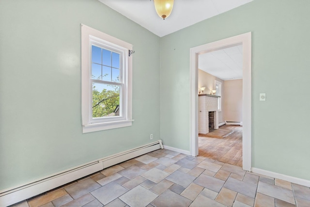 803 Oakwood Dr, Peekskill, NY 10566 - unfurnished room with baseboard heating, a brick fireplace, and baseboards