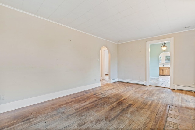 803 Oakwood Dr, Peekskill, NY 10566 - empty room with arched walkways, hardwood / wood-style flooring, crown molding, baseboards, and a baseboard heating unit