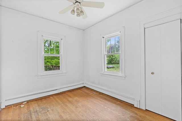 803 Oakwood Dr, Peekskill, NY 10566 - unfurnished bedroom featuring multiple windows, baseboard heating, ornamental molding, light wood finished floors, and a ceiling fan