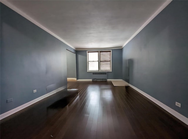 unfurnished room featuring radiator, ornamental molding, baseboards, and wood finished floors