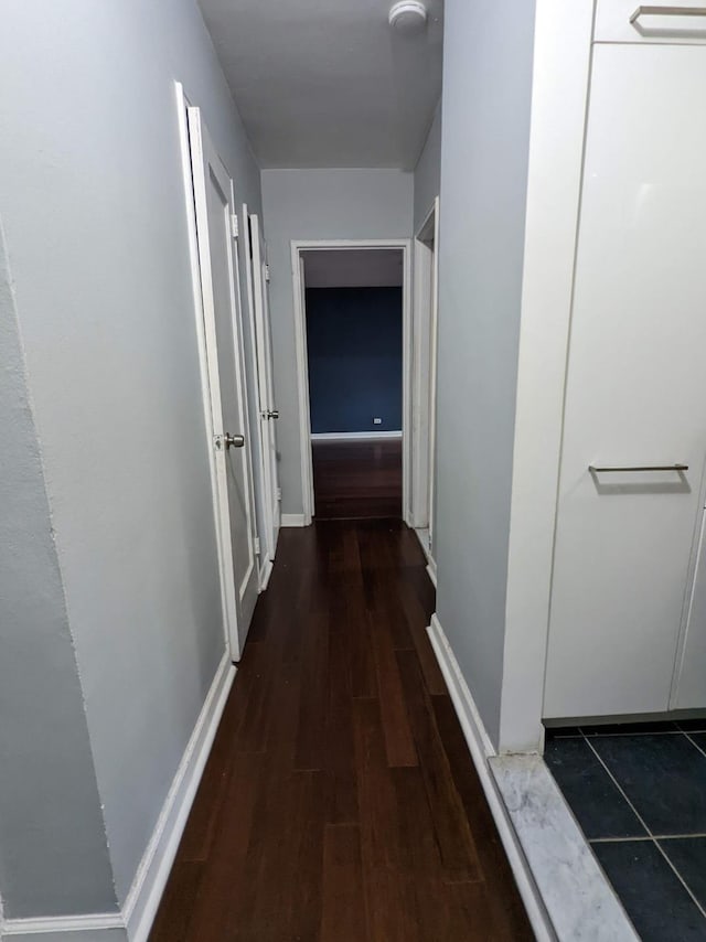 hallway with wood finished floors and baseboards