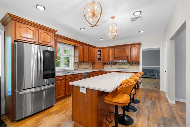 9 Hill Rd, Washingtonville, NY 10992 - kitchen with appliances with stainless steel finishes, a sink, brown cabinetry, light countertops, and wood finished floors