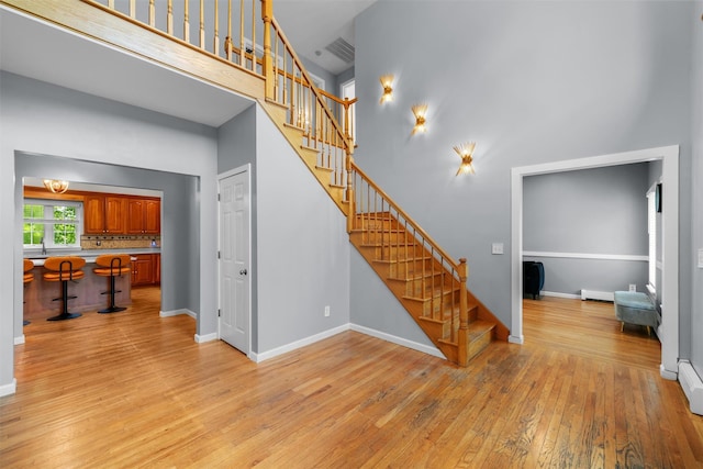 9 Hill Rd, Washingtonville, NY 10992 - stairs featuring a high ceiling, wood-type flooring, baseboards, and a baseboard radiator