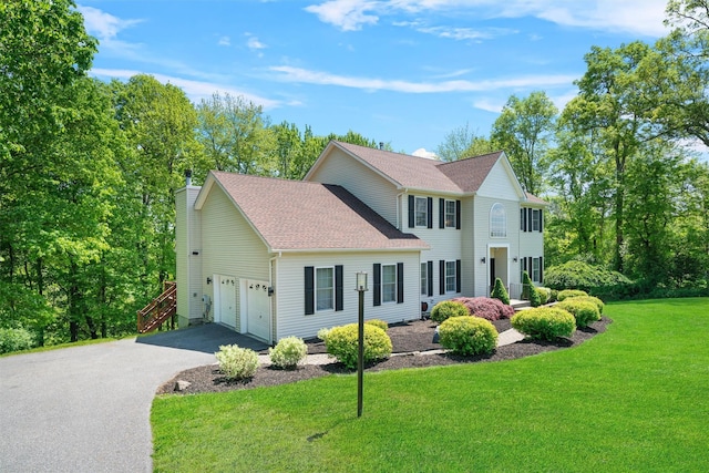 9 Hill Rd, Washingtonville, NY 10992 - colonial house featuring asphalt driveway, a front lawn, an attached garage, roof with shingles, and a chimney