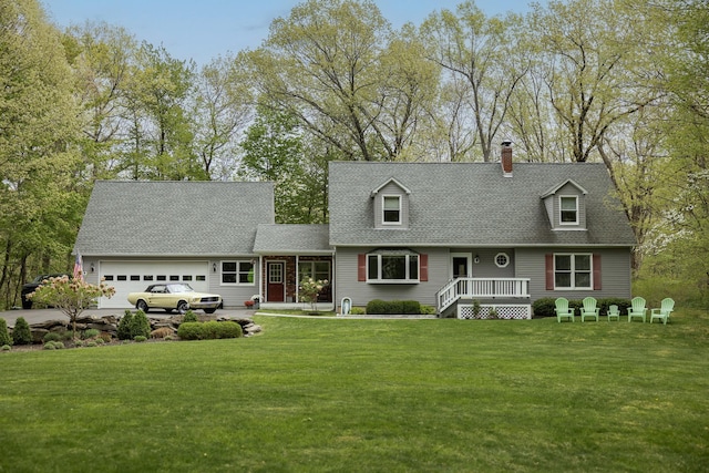 cape cod home with a garage, a chimney, a front yard, roof with shingles, and concrete driveway