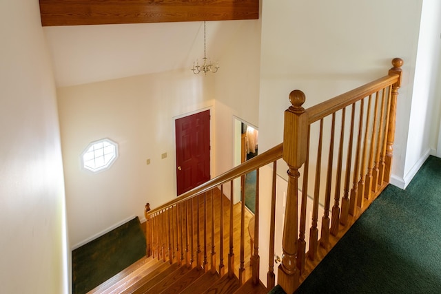 staircase with a chandelier, high vaulted ceiling, and baseboards