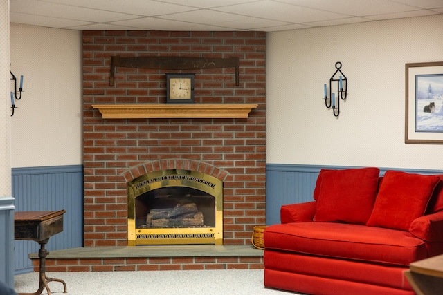 living area with a wainscoted wall and a brick fireplace
