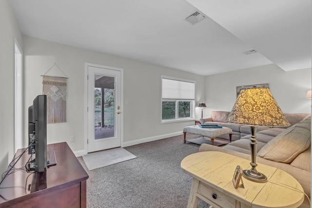 carpeted living area with plenty of natural light and baseboards