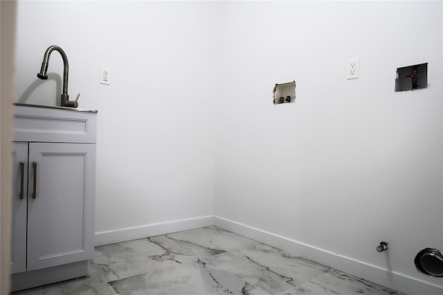 washroom featuring washer hookup, baseboards, cabinet space, light marble finish flooring, and gas dryer hookup