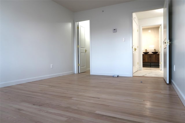 unfurnished bedroom with light wood-style flooring and baseboards