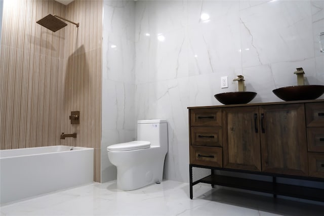 full bath featuring tile walls, toilet,  shower combination, vanity, and marble tiled floors