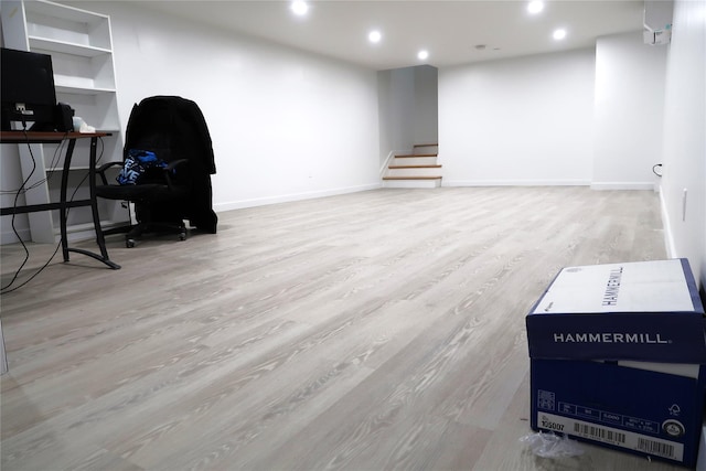 below grade area featuring wood finished floors, recessed lighting, baseboards, stairway, and a desk