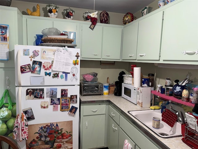 kitchen featuring white appliances, light countertops, and a sink