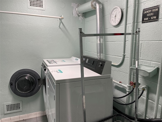 laundry room featuring washing machine and dryer and tile patterned floors