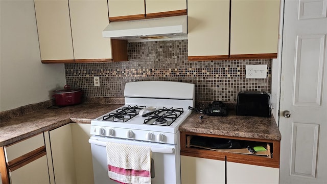 2749 Rte 94, Washingtonville, NY 10992 - kitchen featuring white gas stove, under cabinet range hood, tasteful backsplash, and dark countertops