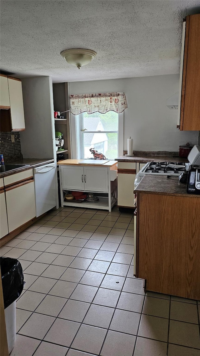 2749 Rte 94, Washingtonville, NY 10992 - kitchen featuring white appliances, dark countertops, a textured ceiling, light tile patterned flooring, and white cabinets