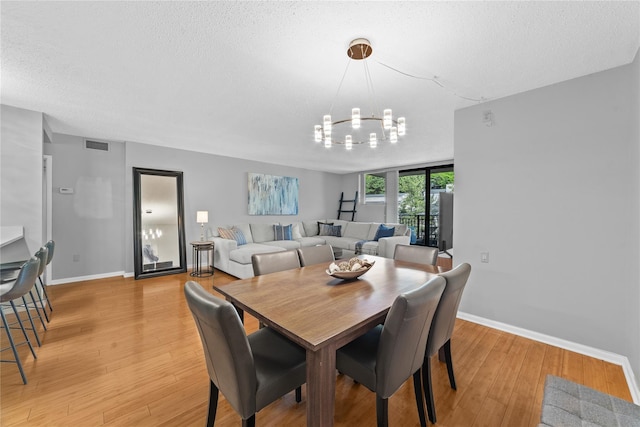 25 Rockledge Ave Unit 501, White Plains, NY 10601 - dining room featuring a chandelier, a textured ceiling, baseboards, and light wood finished floors