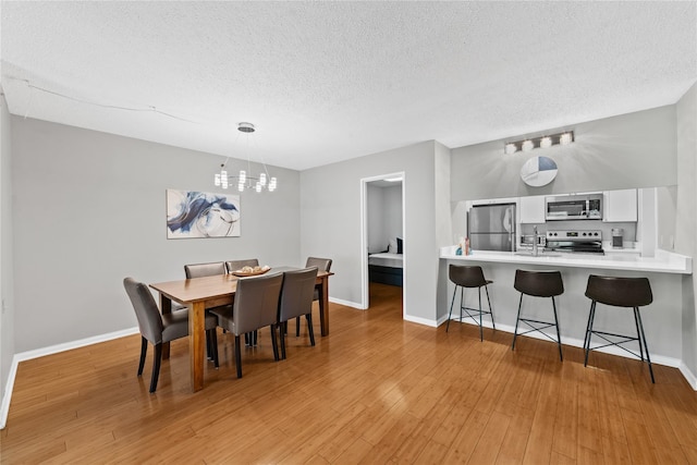 25 Rockledge Ave Unit 501, White Plains, NY 10601 - dining room with a textured ceiling, baseboards, light wood-type flooring, and a chandelier