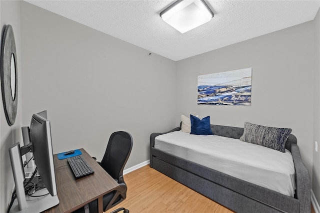 25 Rockledge Ave Unit 501, White Plains, NY 10601 - bedroom with light wood-style floors, a textured ceiling, a desk, and baseboards