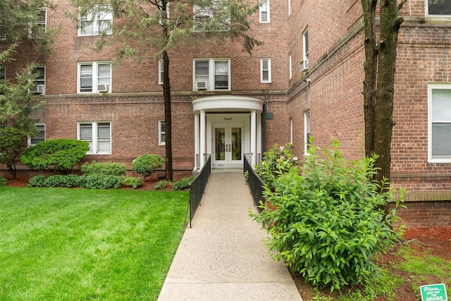 90 Bryant Ave Unit Ftd, White Plains, NY 10605 - view of exterior entry featuring french doors, brick siding, and a yard