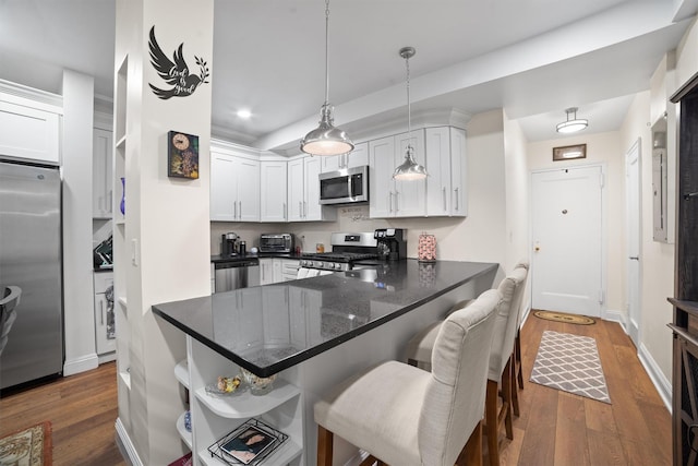 90 Bryant Ave Unit Ftd, White Plains, NY 10605 - kitchen with appliances with stainless steel finishes, a peninsula, white cabinetry, dark wood finished floors, and recessed lighting