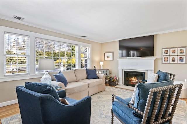 living room featuring crown molding, a glass covered fireplace, wood finished floors, and baseboards
