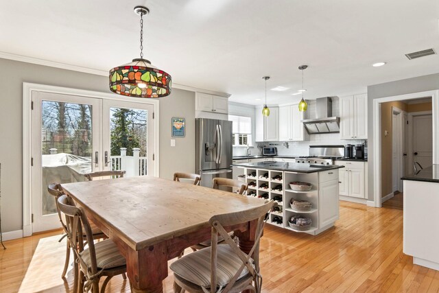 dining area with light wood finished floors, recessed lighting, baseboards, french doors, and crown molding