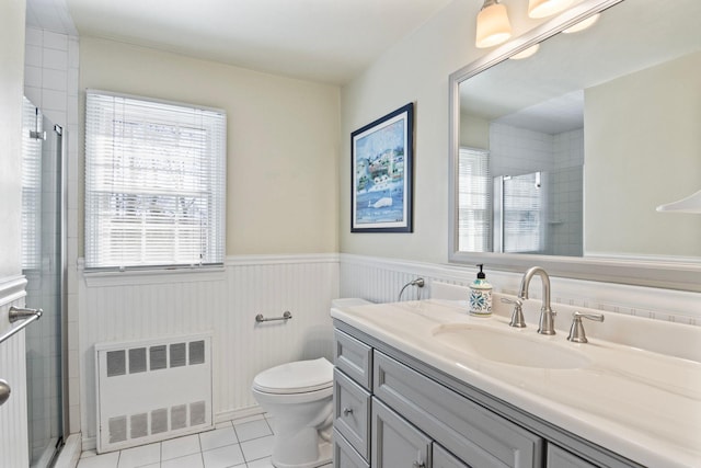 bathroom featuring radiator, tiled shower, tile patterned flooring, a wainscoted wall, and vanity