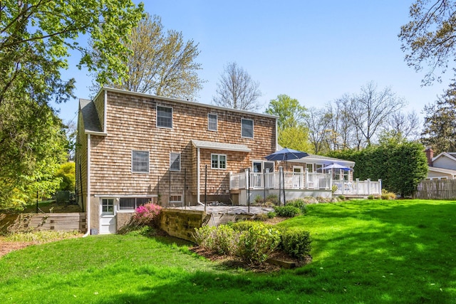 rear view of house with a lawn and a deck