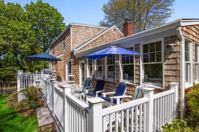 rear view of property with a chimney and a wooden deck