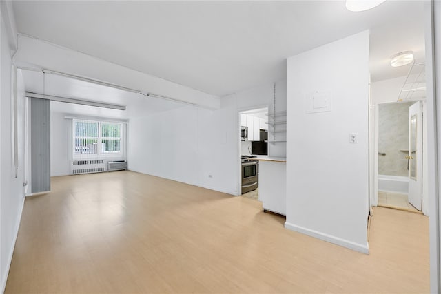 142-05 Roosevelt Ave Unit 331, Flushing, NY 11354 - unfurnished living room featuring radiator heating unit, light wood-type flooring, and baseboards